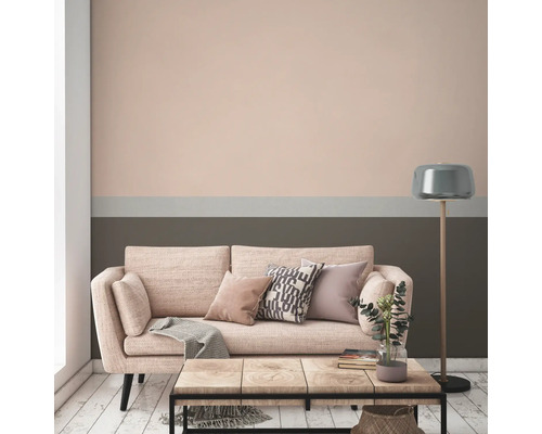 Wohnzimmer mit Sofa, Tisch und Stehlampe vor einer Wand mit Farbanstrich