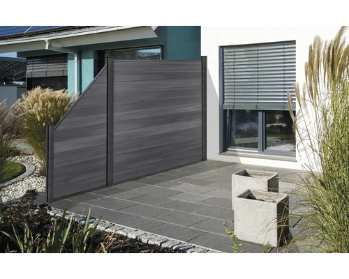 Clôture en bois dans un jardin avec des plantes et des pavés