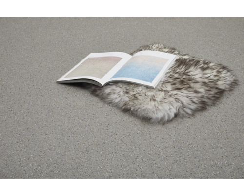 Offenes Buch liegt auf einem Fellteppich auf einem Bodenbelag.