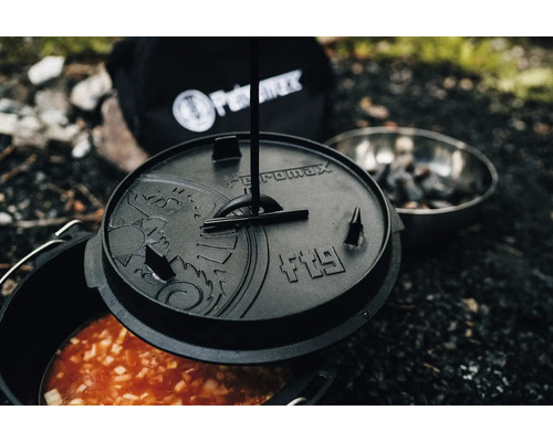 Petromax Feuertopf mit Deckel, Speise und Petromax Logo im Hintergrund