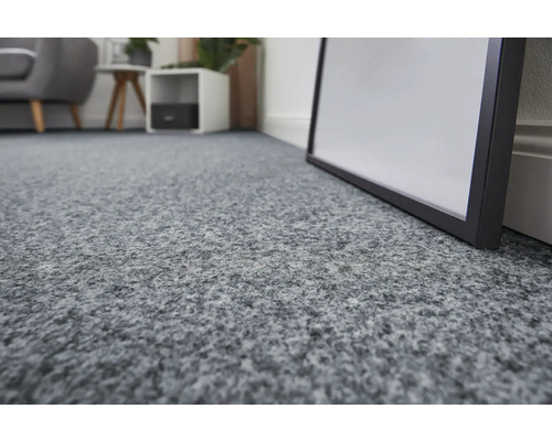 Gros plan d'un revêtement de sol textile gris dans un espace de vie.