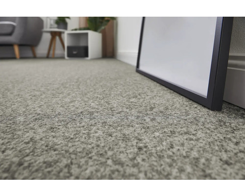 Gros plan d'un tapis de couleur claire dans un salon.