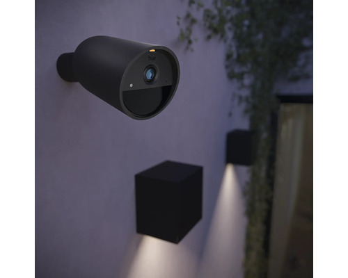 Außenansicht mit einer drahtlosen Philips Hue Überwachungskamera an der Wand, sowie zwei würfelförmige Wandleuchten