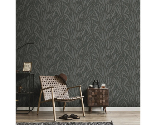 Zimmer mit dunkler Blättertapete, Sessel, Nachttisch und Dekoration