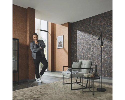 Wohnzimmer mit gemusterter Tapete, Sessel, Stehlampe und Teppich