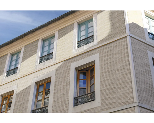 Außenansicht eines Gebäudes mit Ziegelmauerwerk und mehreren Fenstern