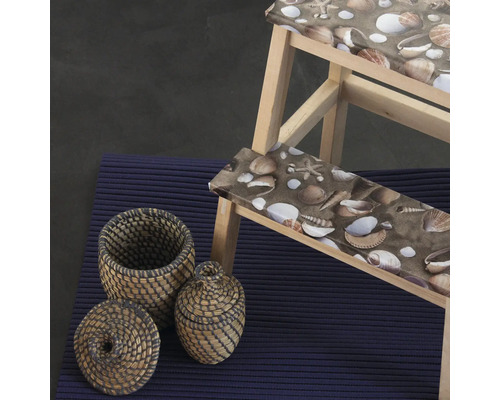 Scène avec tabouret en bois à motifs de coquillages, deux paniers et un tapis