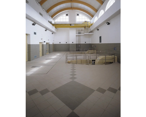 Vue intérieure d''une grande pièce avec carrelage, grue et fenêtres