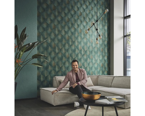 Wohnzimmer mit geometrischer Tapete, Ecksofa, Zimmerpflanze und dekorativer Beleuchtung für ein stilvolles Ambiente