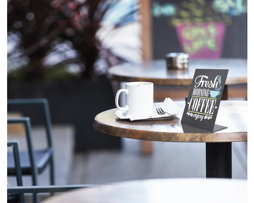 Szene im Freien mit Tasse Kaffee, Gedeck und Tischaufsteller auf einem Tisch