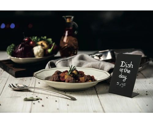 Speisekarte mit Tagesgericht und Preisangabe auf einem Tisch mit Essen