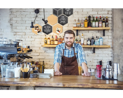 Scène de restauration avec barman derrière le comptoir et décorations murales hexagonales