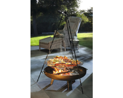 Scène de barbecue avec barbecue à trépied, grillades et mobilier de jardin