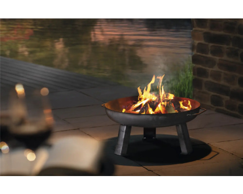 Brasero avec bois brûlant dans le jardin