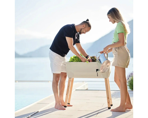 Personen gärtnern in einem Hochbeet mit Blick auf einen See