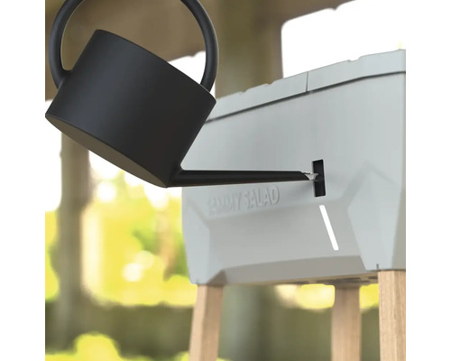 Giesskanne füllt ein Hochbeet mit Wasserspeicher