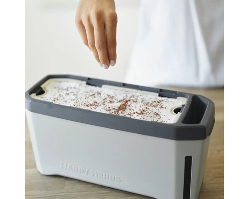 Eine Hand sät Samen in einen Kräutergarten von Harry Herbs.