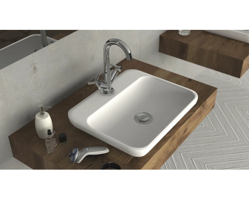 Lavabo avec robinet, distributeur de savon et rasoir sur étagère en bois dans la salle de bains