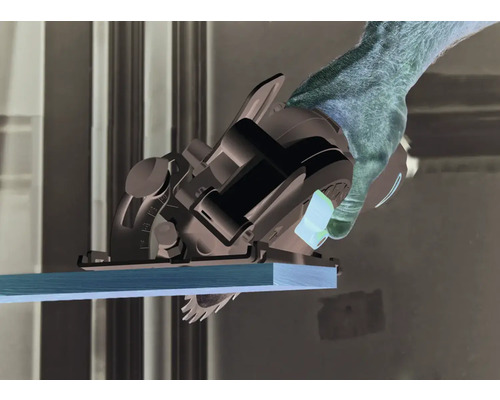 Une main utilise une scie circulaire portative pour scier une planche de bois.