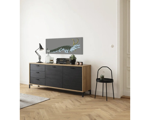 Wohnzimmer mit Sideboard, Tischleuchte, Deko-Objekten und Wandbild
