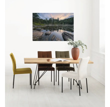 Esszimmer mit Holztisch und farbigen Polsterstühlen unter einem Landschaftsgemälde.