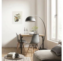 Heller Wohnraum mit Holztisch, Stühlen, Bogenlampe und Vogelbild
