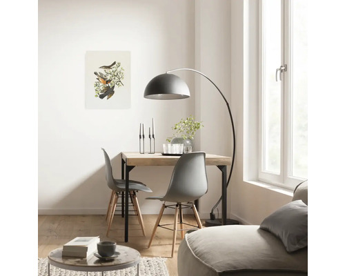 Heller Wohnraum mit Holztisch, Stühlen, Bogenlampe und Vogelbild
