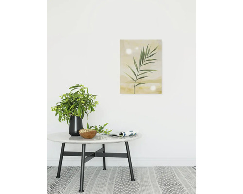 Dekoratives Interieur mit Tisch, Blumenvase und gerahmtem Pflanzenbild an der Wand