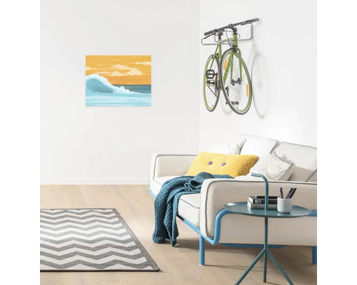 Wohnzimmer mit Sofa, Beistelltisch, Teppich, Bild und Fahrradhalterung mit Fahrrad