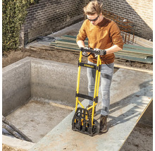 Une personne utilise un monte-escalier Stanley pour transporter des matériaux de construction sur un chantier.
