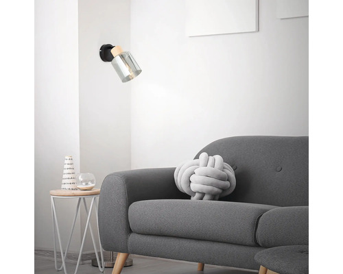 Wandleuchte aus Holz und Glas neben einem Sofa in einem Wohnzimmer