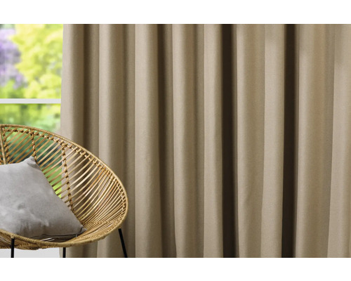 Rideau décoratif à côté d''un fauteuil en rotin devant une fenêtre