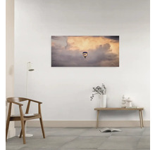 Wandbild mit einem Heißluftballon vor Wolken in einem Zimmer.