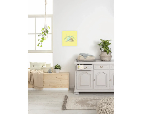Scène d''une pièce lumineuse avec une commode, une caisse en bois, un tapis et une image encadrée avec l''inscription Precious Bounty au mur