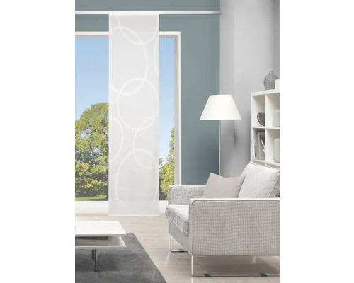 Salon avec rideau coulissant à motif circulaire, fauteuil, lampadaire et étagère