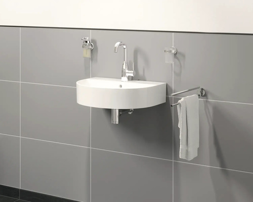 Halbrundes Waschbecken mit Armatur, Seifenspender, Zahnputzbecher und Handtuchhalter an einer grauen Wand