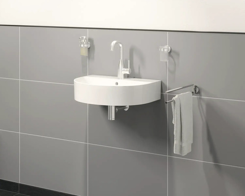 Halbrundes Waschbecken mit Armatur, Seifenspender, Zahnputzbecher und Handtuchhalter im Badezimmer