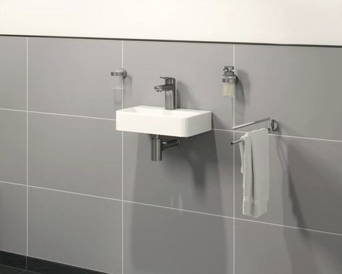 Salle de bains moderne avec petit lavabo, robinet, distributeur de savon et porte-serviettes