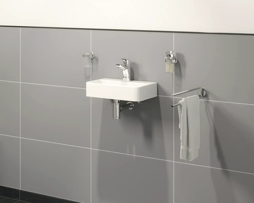 Helles Badezimmer mit rechteckigem Waschbecken, Armatur, Handtuchhalter, Seifenspender und Zahnputzbecher