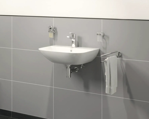 Keramikwaschbecken mit Armatur, Seifenspender, Zahnputzbecher und Handtuchhalter im Badezimmer