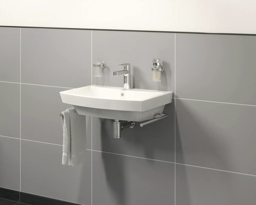 Hängewaschtisch mit Armatur und Accessoires an grauer Wand