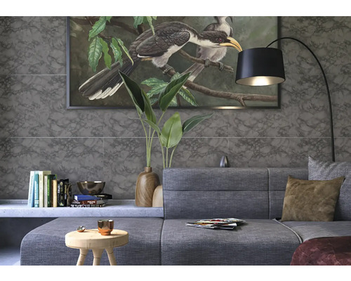 Salon avec canapé gris, lampadaire et carreaux muraux imitation marbre