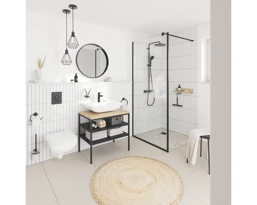 Helles Badezimmer mit Dusche, Waschtisch, Toilette und rundem Teppich
