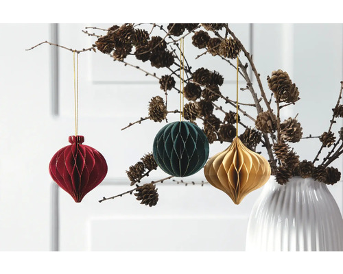 Boules de Noël décoratives suspendues à une branche dans un vase