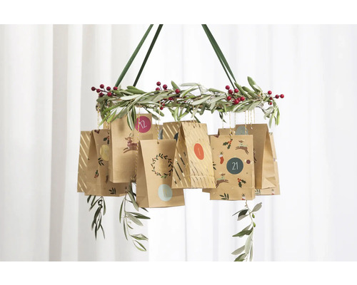 Calendrier de l''Avent suspendu avec des sacs en papier sur une couronne