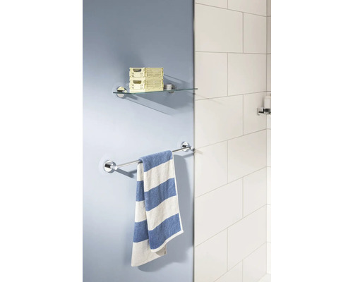 Vue de salle de bains avec étagère en verre, porte-serviettes et serviette rayée