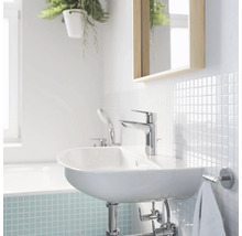 Salle de bain lumineuse avec lavabo, robinet, miroir et carrelage