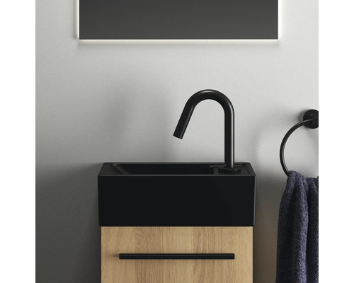 Waschtisch mit schwarzem Becken und Armatur sowie Holzunterschrank im Badezimmer