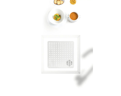Quadratische Abtropfschale mit Lochmuster auf einem Tisch mit Speisen