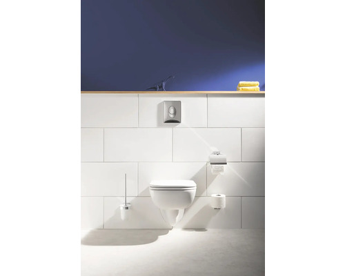 WC suspendu avec plaque de commande, porte-papier toilette et brosse WC dans une salle de bain claire.